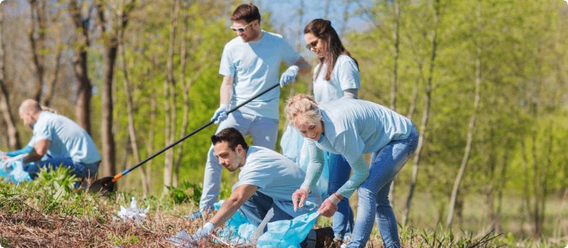 A group of youth and adults cleaning a park together.