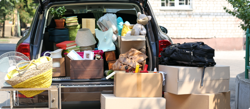 a stack of boxes and belongings in the back of a car