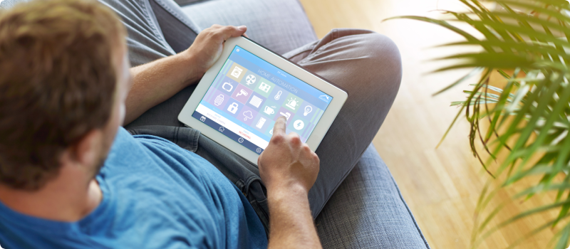 Man monitoring home security system on a tablet