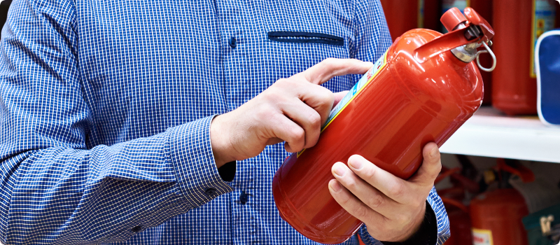A man reading the label on a new fire extinguisher