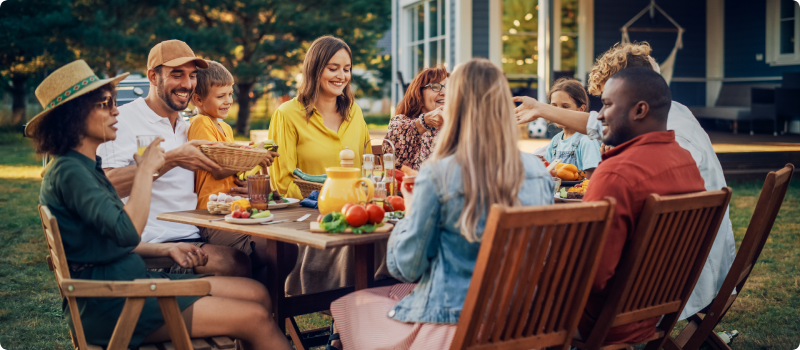 People having dinner in the backyard.