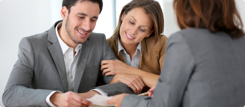 a man and woman signing documents with a banker