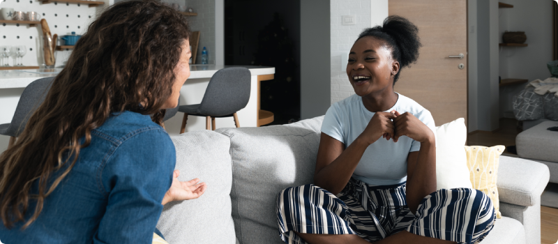 two women talking on a couch