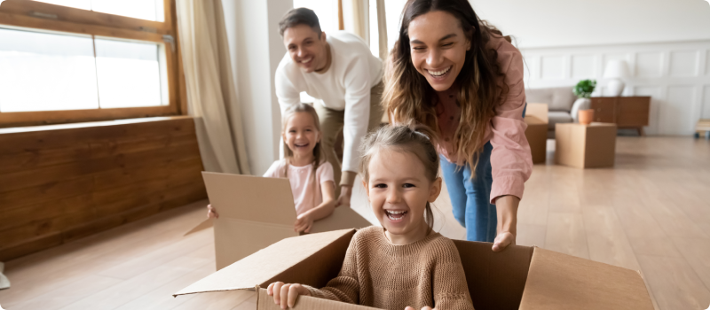 Parents playing with their daughters using moving boxes