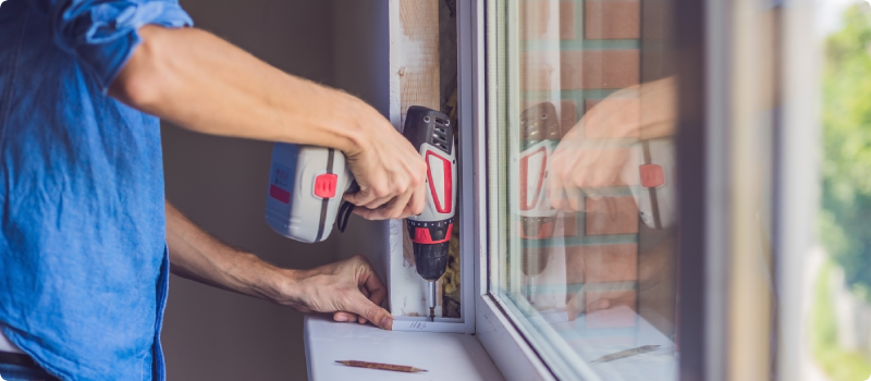 Man with a drill installing a window