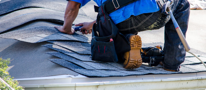 a worker fixing roof tiles