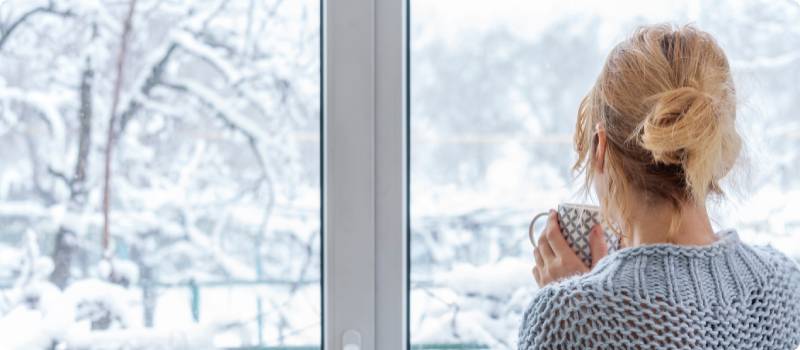 a woman looking out the window in the winter