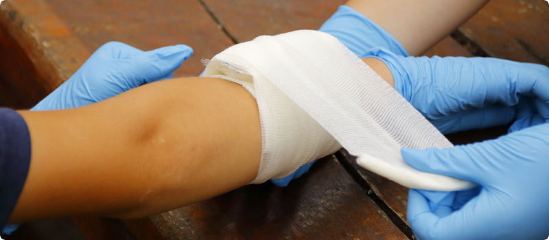 Creating pressure bandage of a wound on a forearm.