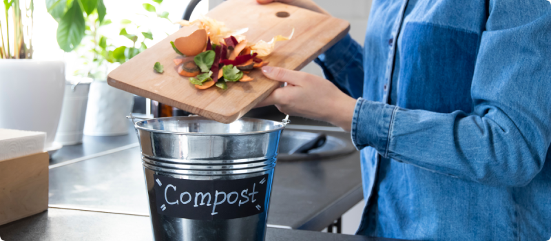 a person putting food scraps into a composting bin