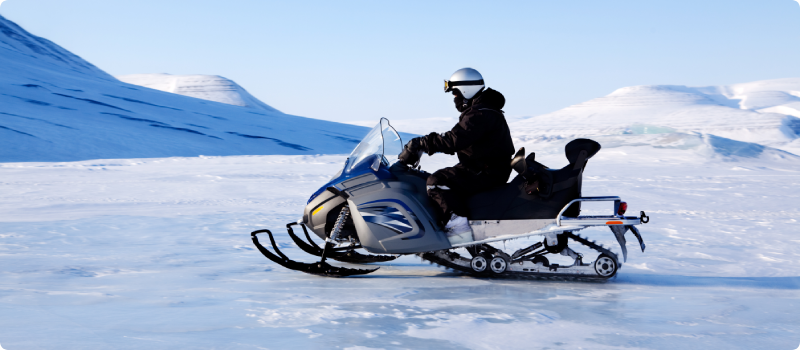 A snowmobile on a beautiful winter mountain landscape.