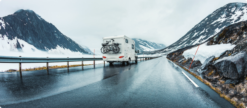 RV traveling through mountain area during winter weather
