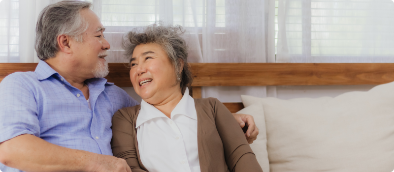 elderly couple smiling on a couch