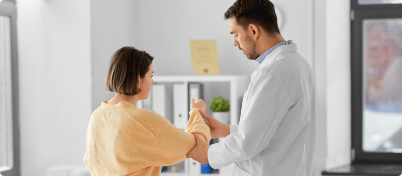 a doctor examining a woman's arm