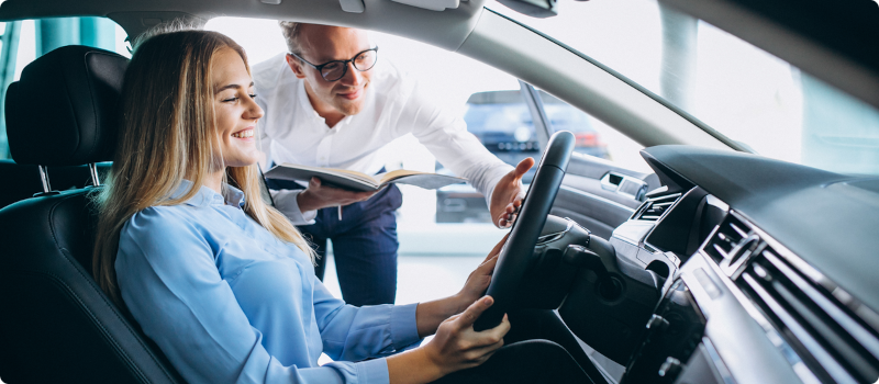 a salesman showing a woman a car