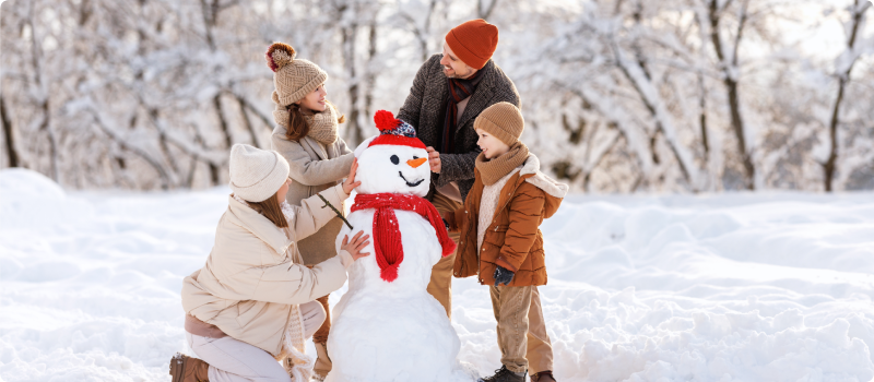 Parents and kids sculpting a snowman