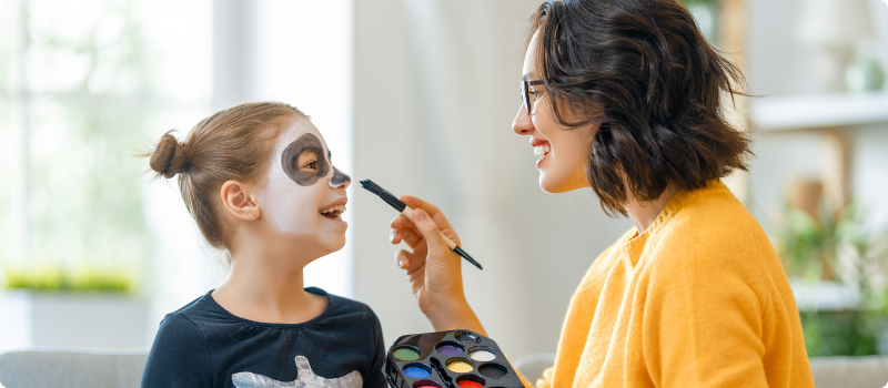 a woman painting a young girl's face