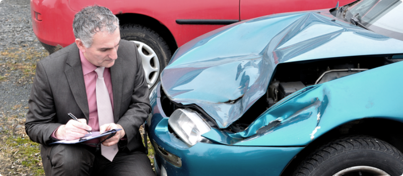 an insurance adjuster inspecting a damaged car