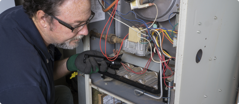 a repairman fixing a furnace