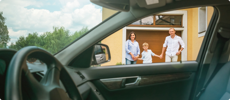 Couple and son standing by garage door
