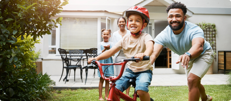 Father teaching his son how to ride a bicycle.
