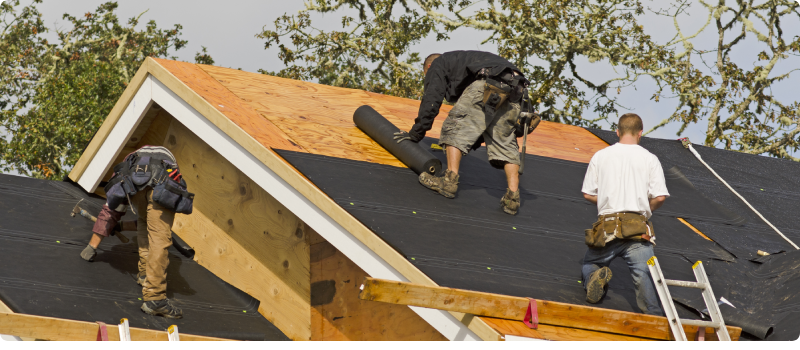 workers installing a roof on a home