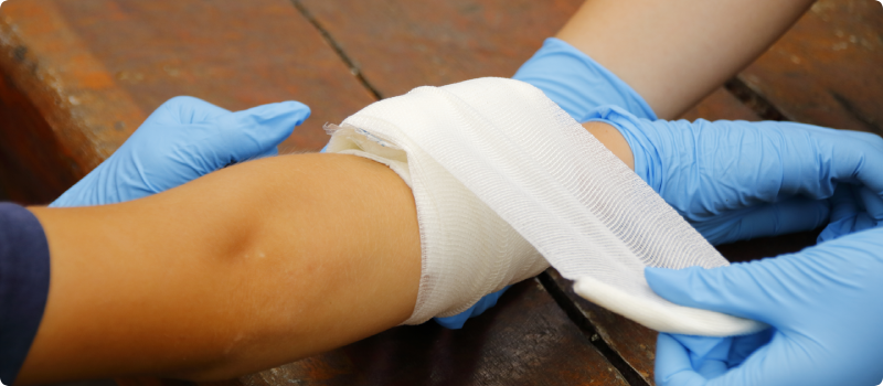 an injured arm being wrapped in gauze