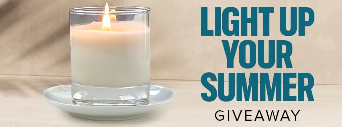 white candle, lit, on a cream background