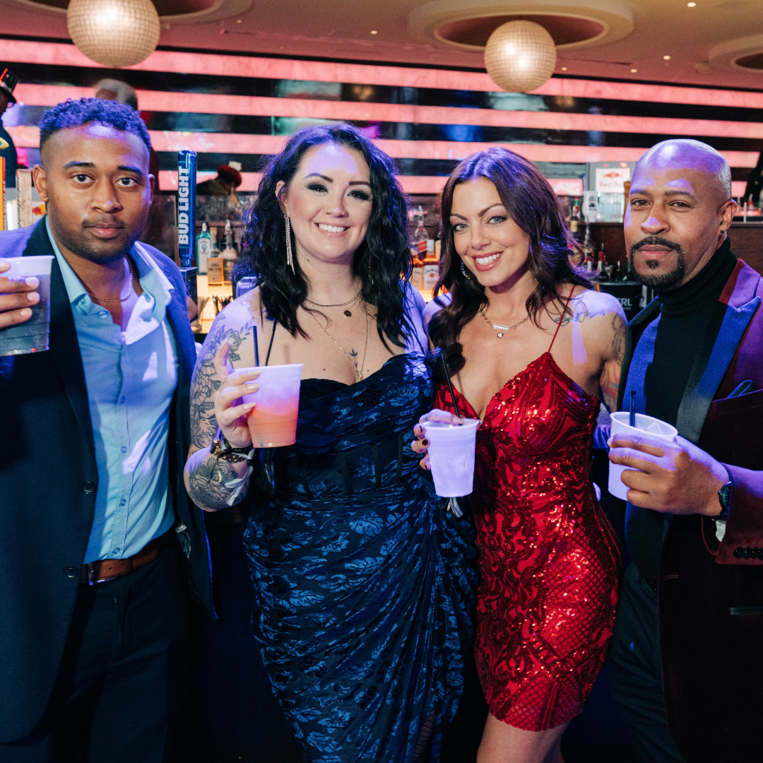 Group of friends posing with drinks celebrating New Year's Eve at Ballpark Village