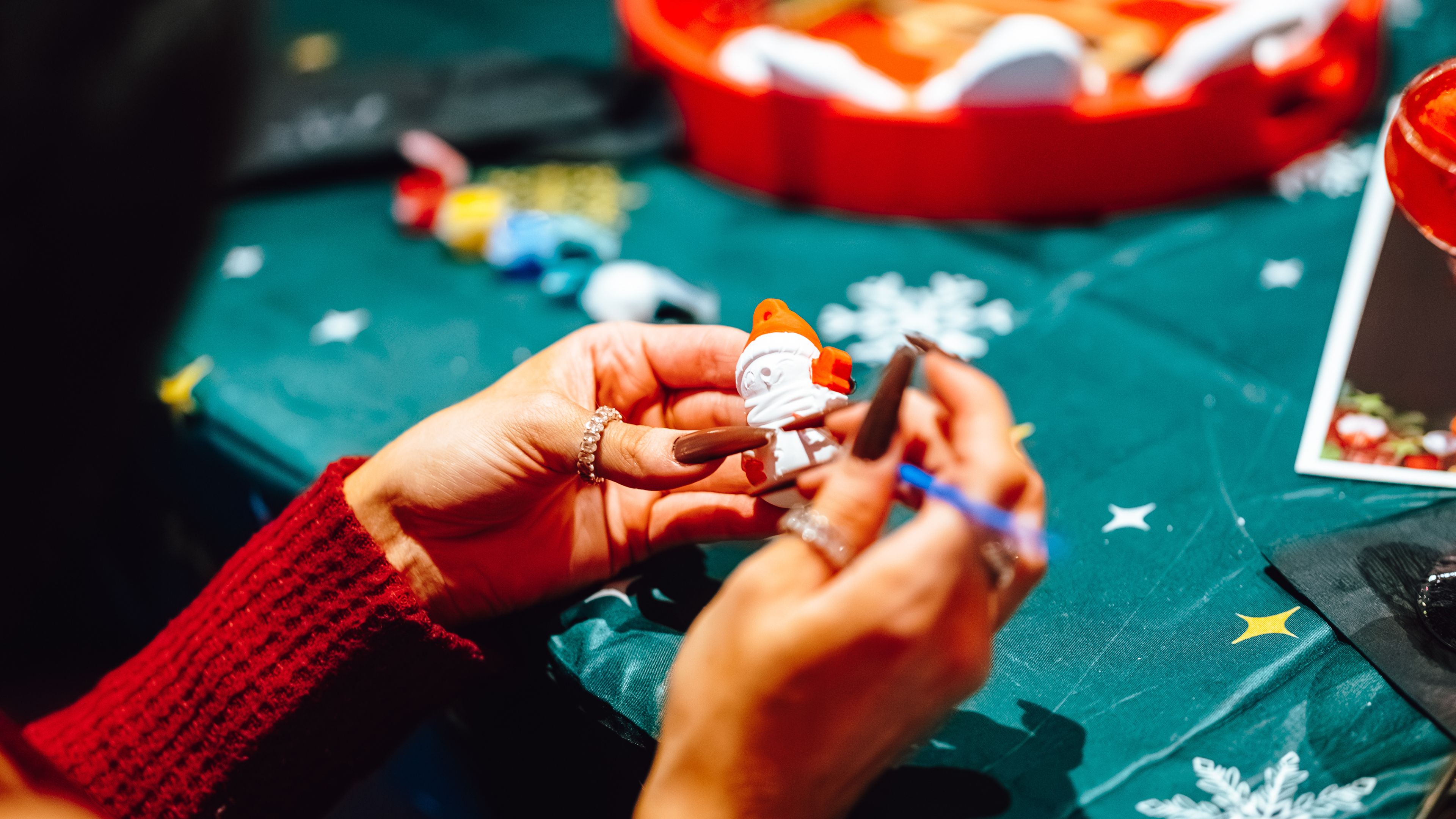 An image of someone painting an ornament at Tinsel Tavern.