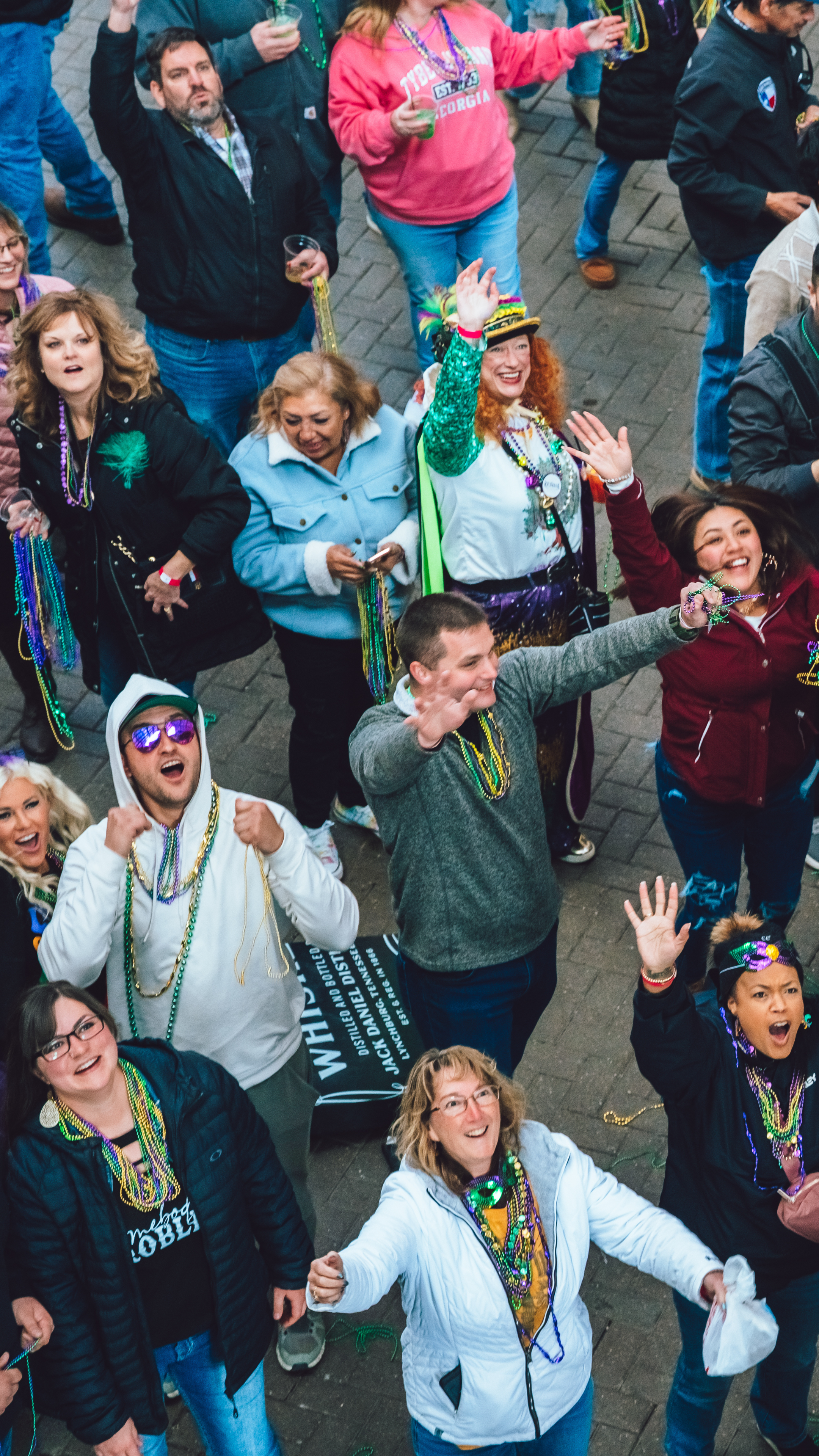 People trying to catch beads at Mardi Gras Live!