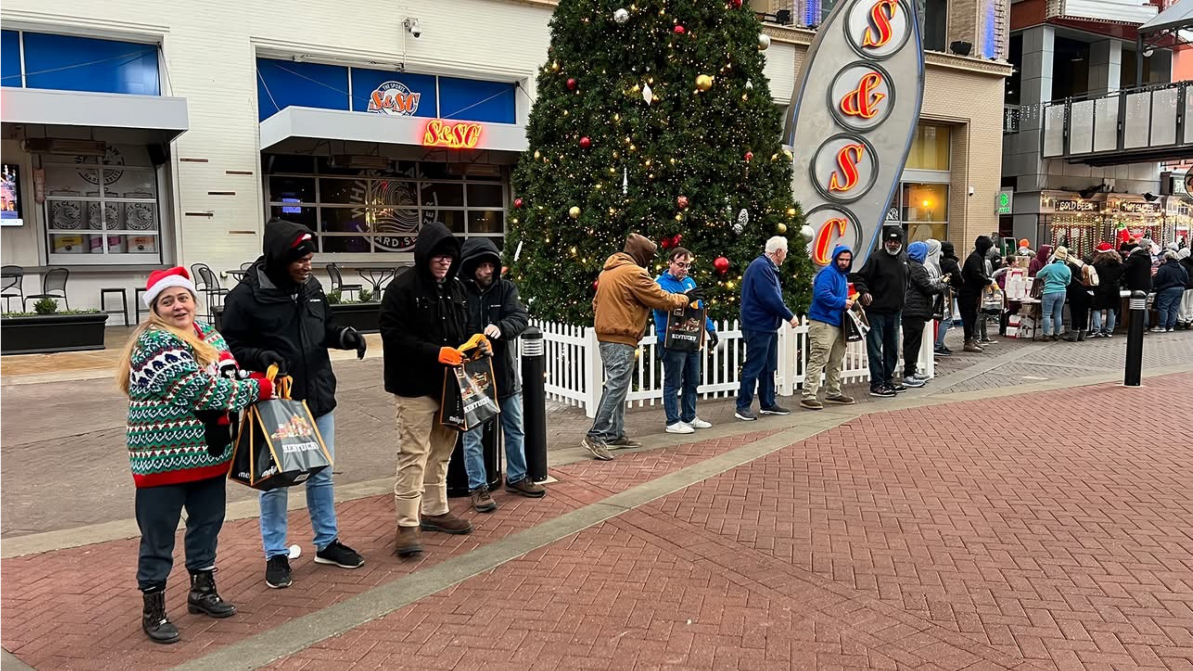 Volunteers passing boxes of food down an assembly line.