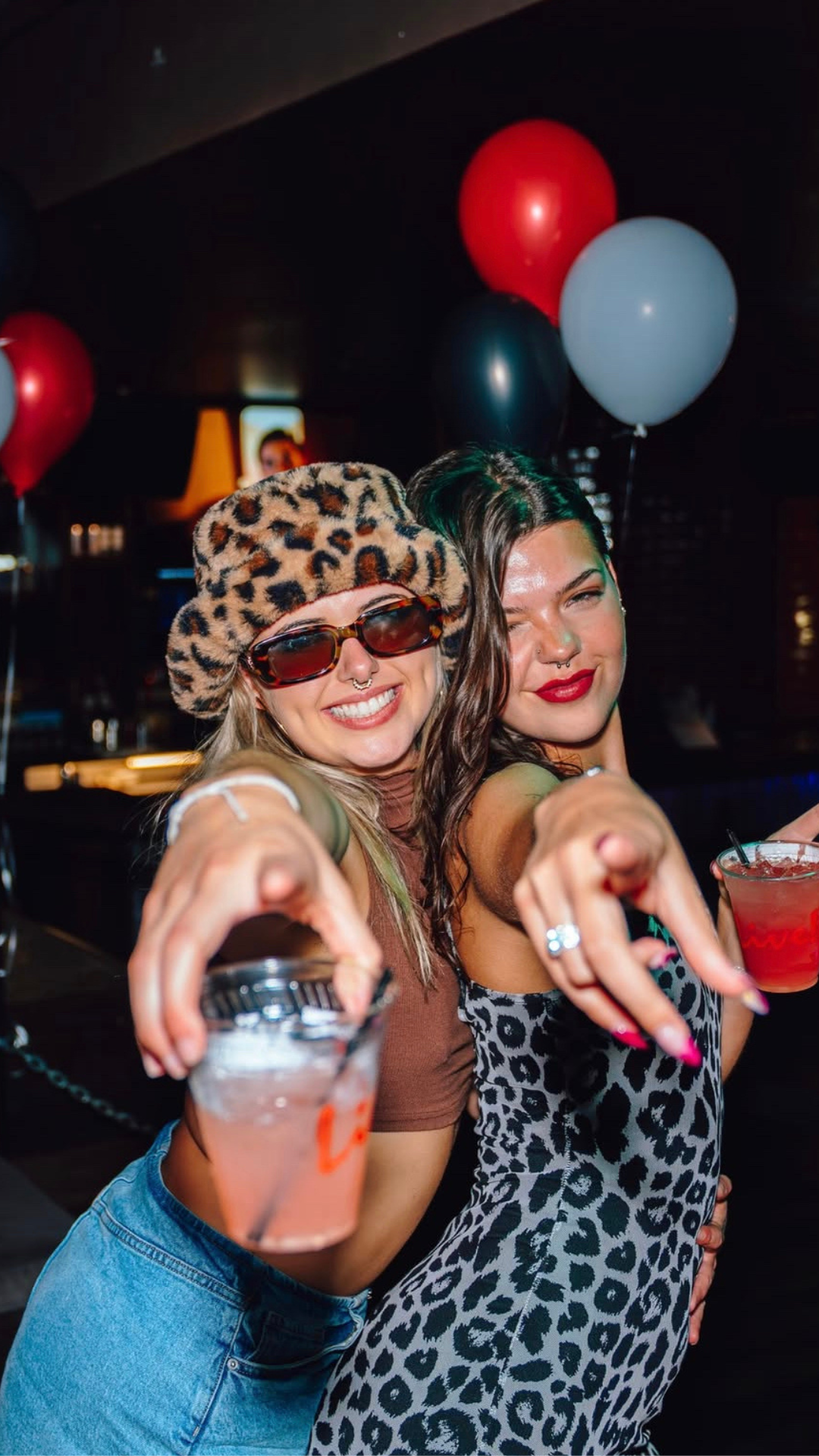 An image of two girls pointing at the camera.