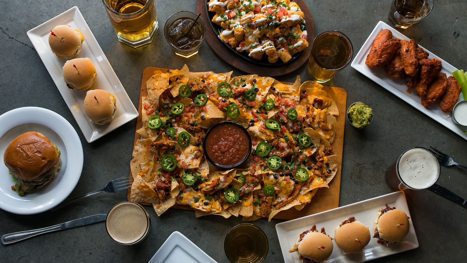 McFadden's - Overhead view of nachos, sliders, and other dishes