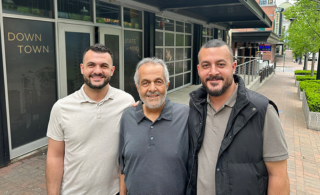 Brothers Dennis and Adam Alazzeh with their father Farid Alazzeh, in downtown Kansas City's Power & Light District; photo by Joyce Smith