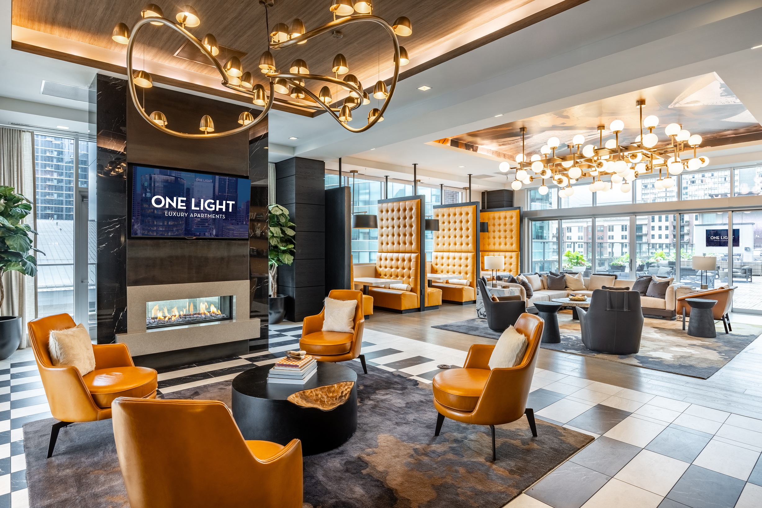 One Light luxury apartment building common space lounge featuring seating and fireplace.