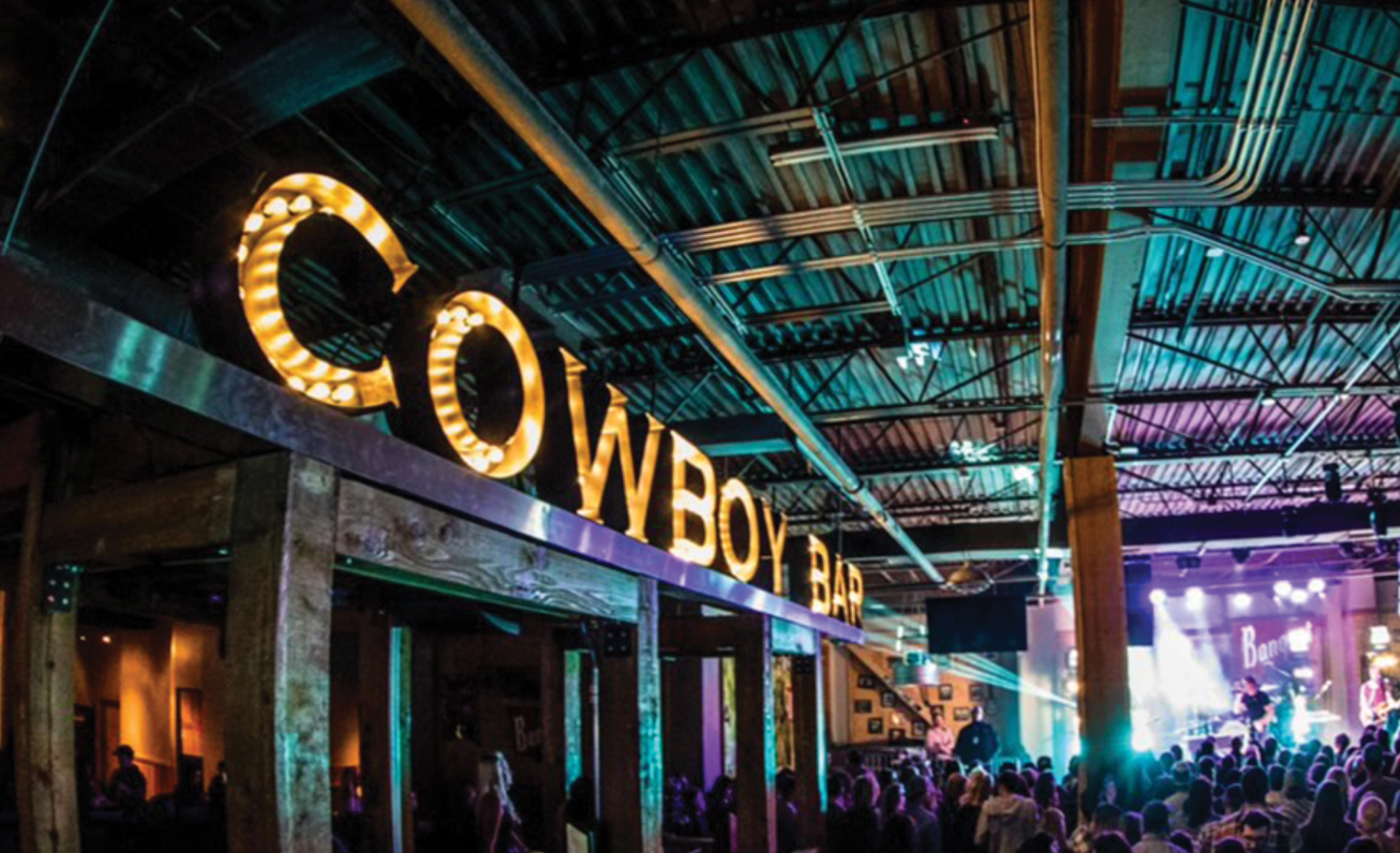 PBR Cowboy Bar neon sign in venue.