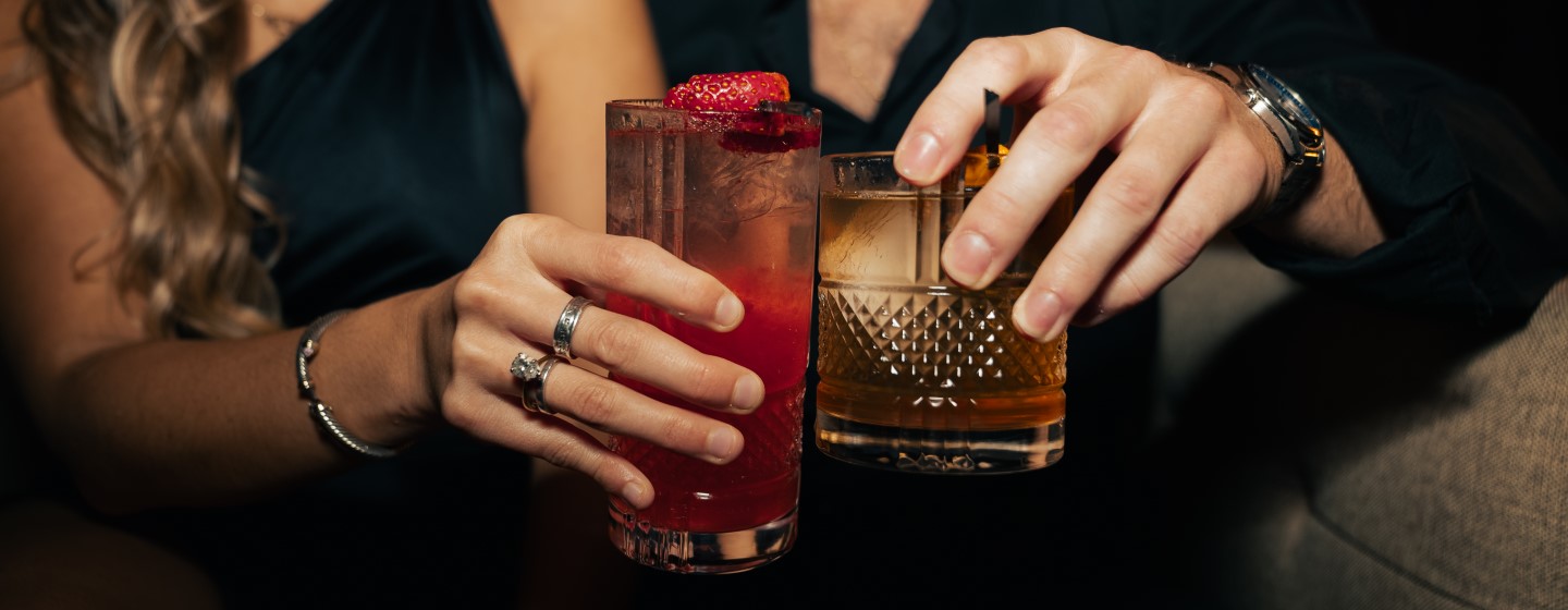 Women and man toasting cocktails at Houndsmen Lounge, Live! at the Pointe Orlando.