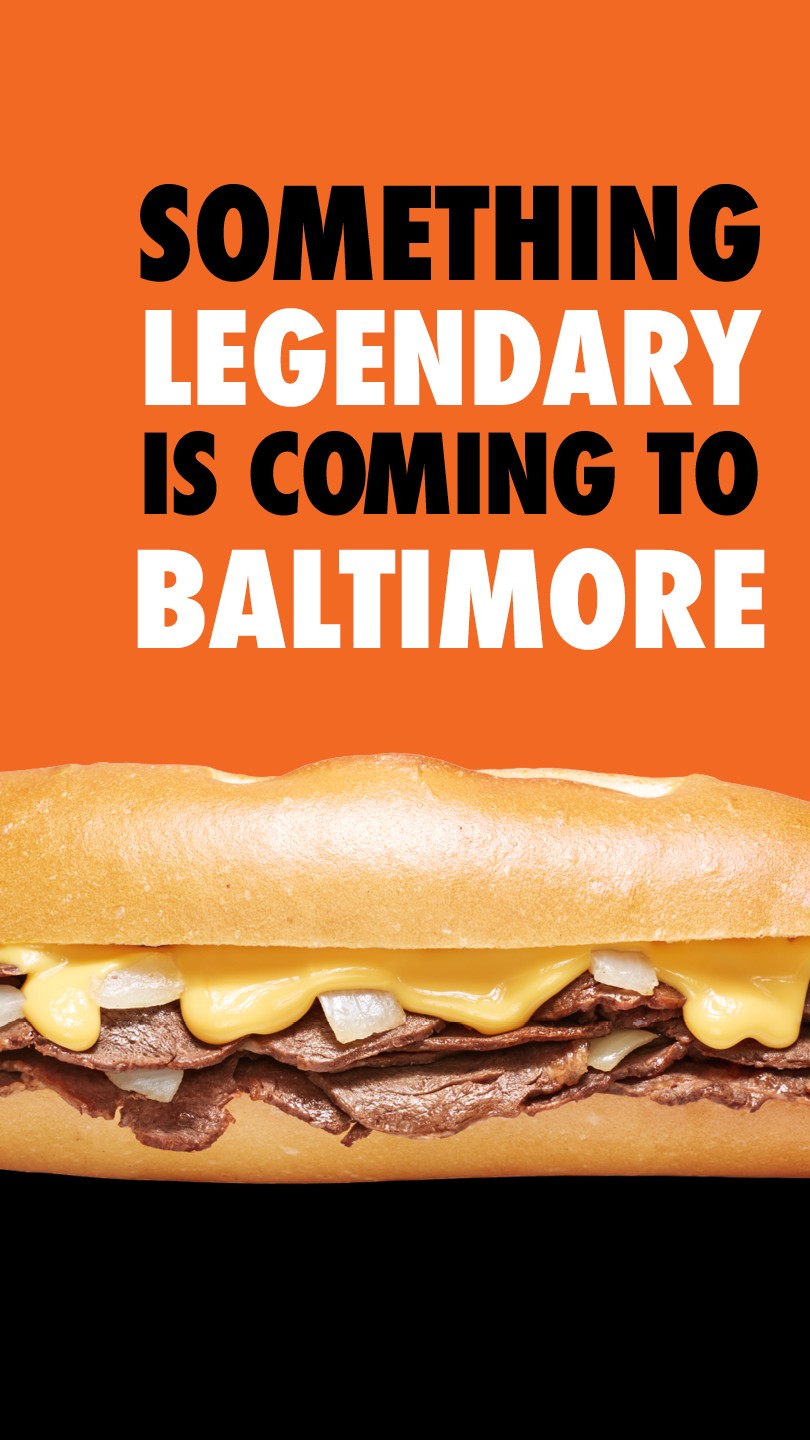 Text - Something Legendary is Coming To Baltimore - against orange background with cheesesteak photo below.