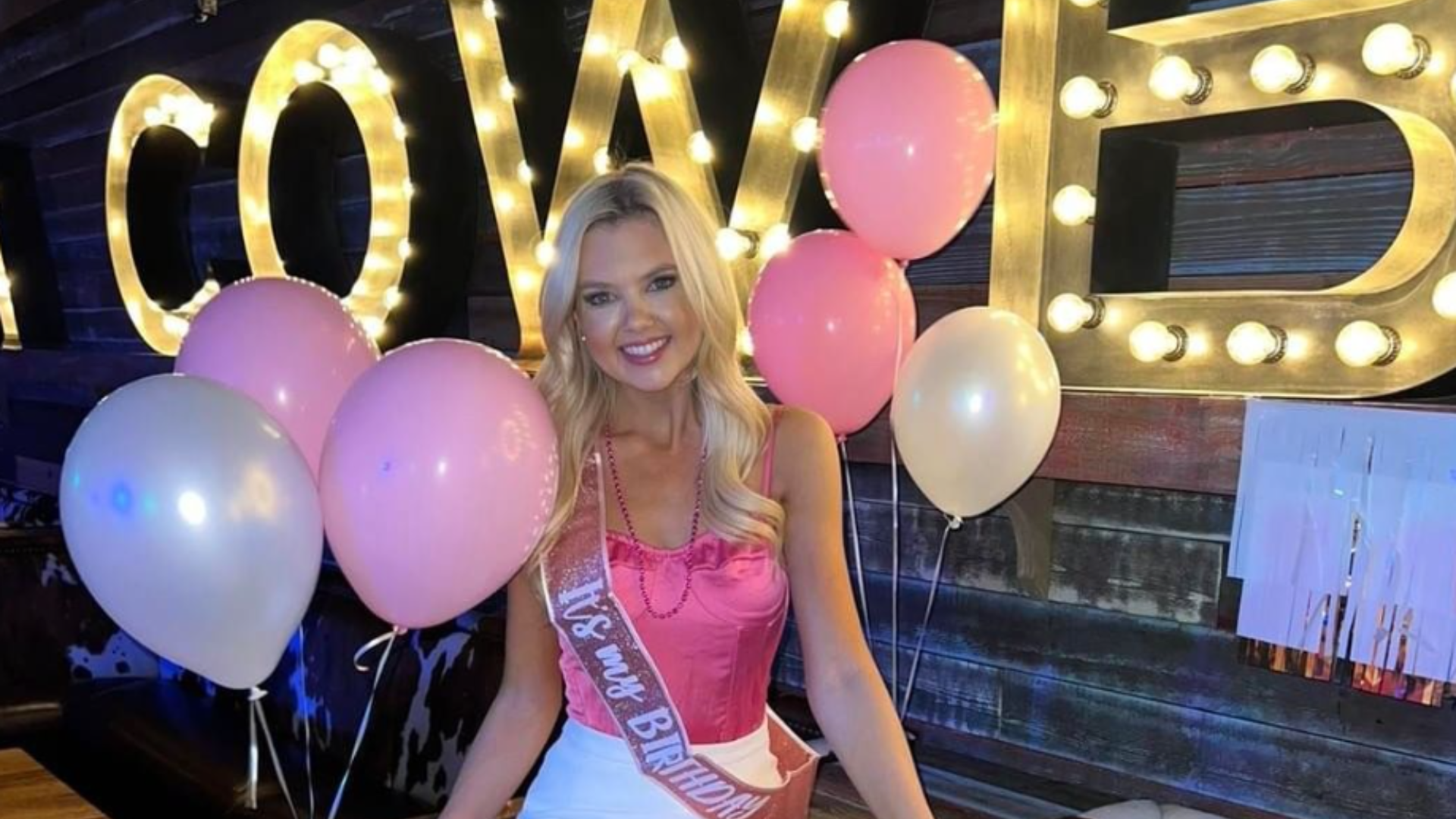 Female guest with balloons celebrating birthday at PBR Cowboy Bar.