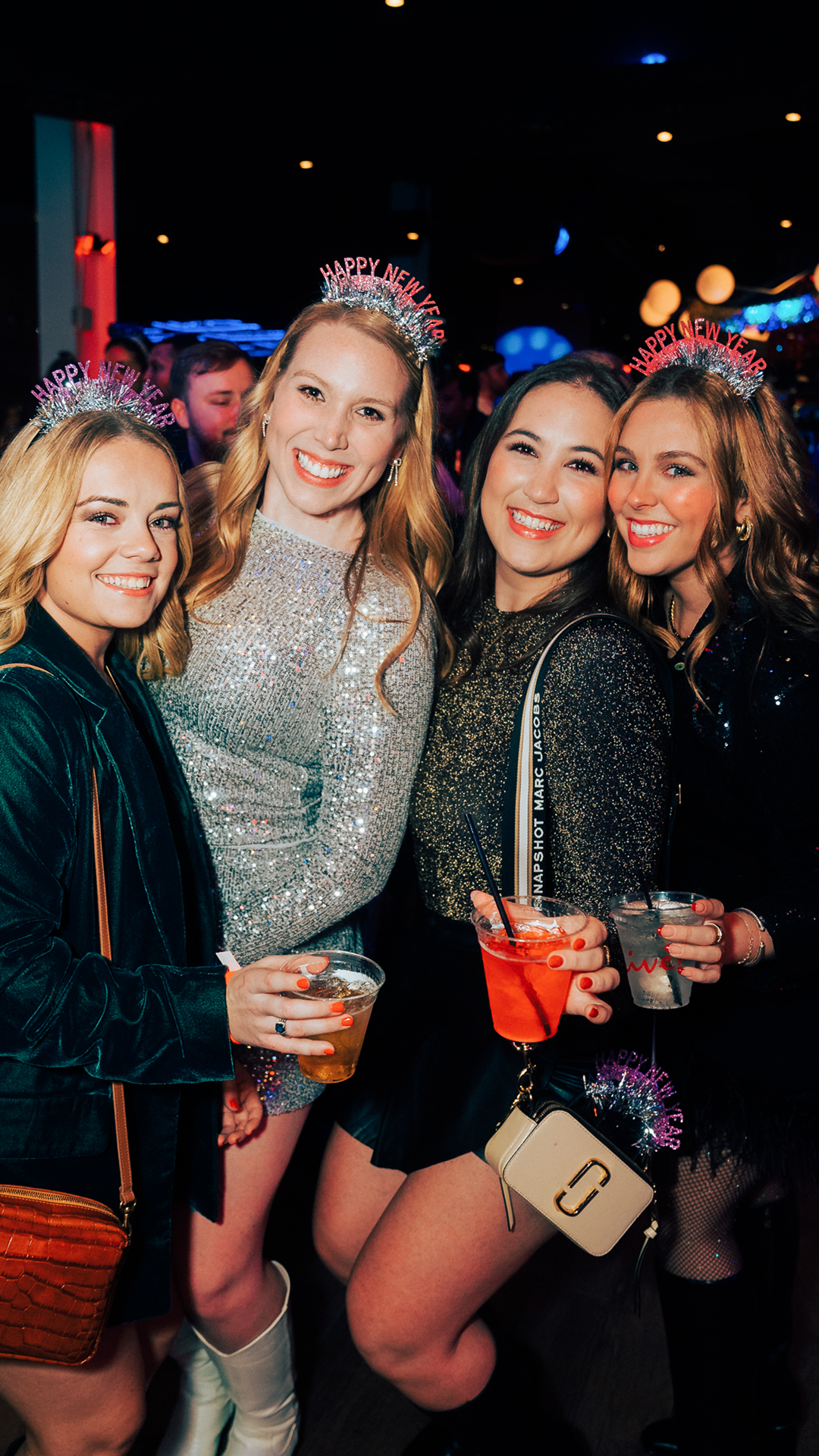 Four women taking a picture with drinks in their hands