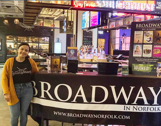 Woman standing next to SevenVenues event booth.