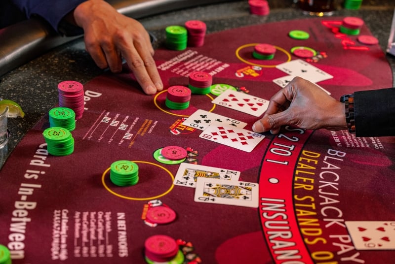 Image of a blackjack table and a player asking to hit on their hand