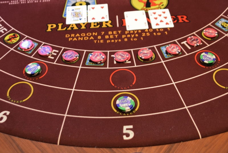 Image of a table felt for EZ Bacc with casino chips and cards
