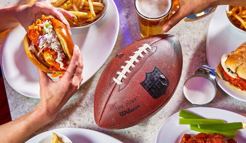 image of a football on a table full of food and beer at sports & social louisiana