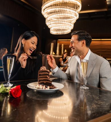 image of a couple sharing a piece of cake with champagne at the prime rib louisiana