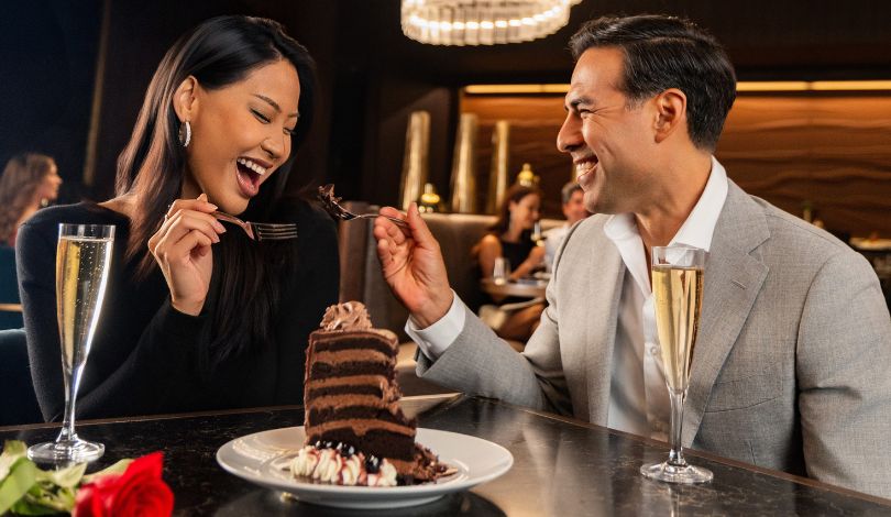 image of a couple sharing a piece of cake with champagne at the prime rib louisiana