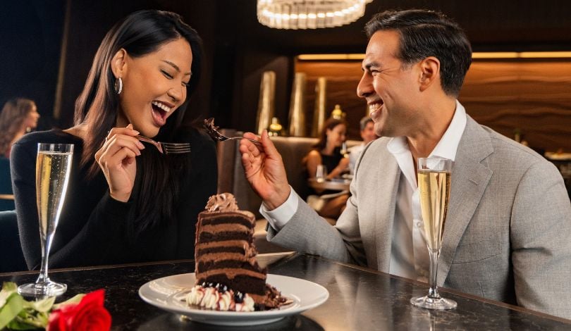 image of a couple sharing a piece of cake with champagne at the prime rib louisiana