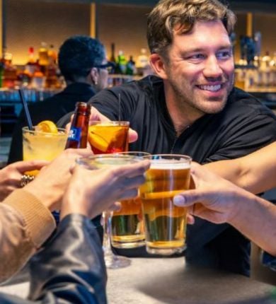 image of a group of people clinking their glasses together at sports & social louisiana