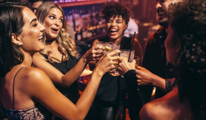 image of 5 women clinking their cocktail glasses together