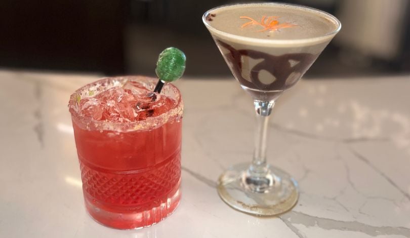 image of a red cocktail in a short glass with a green lollipop and a martini with a fake toy spider in it